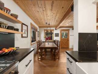 Experience rustic charm in this inviting dining area, featuring a substantial wooden table and chairs perfect for family gatherings.