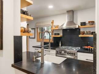 Discover this charming kitchen featuring a deep farmhouse sink and a high-arc faucet, perfect for any culinary task.