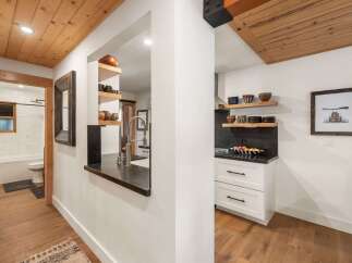 Experience the charm of this rustic kitchen and hallway, featuring warm wood ceilings and floors that create a cozy ambiance.