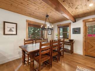 Experience rustic charm in this inviting dining room, featuring a substantial wooden table and chairs perfect for family gatherings.