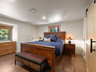 Experience rustic charm in this cozy bedroom, featuring a sturdy wooden bed frame and matching nightstands.