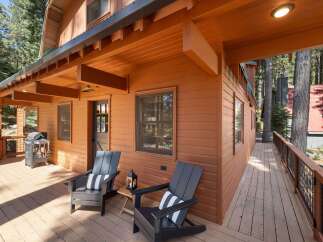 Enjoy the serene mountain setting from this charming cabin's spacious wooden deck.