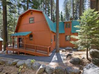 Nestled among tall pine trees, this charming wooden cabin offers a serene mountain retreat.