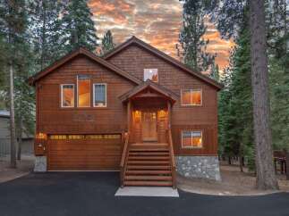 Nestled among tall pine trees, this charming wooden home offers a warm and inviting atmosphere.