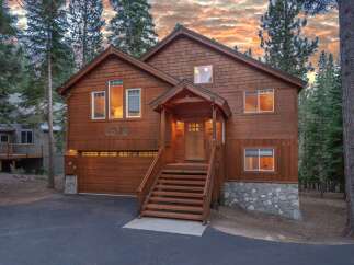 Nestled amidst tall pine trees, this charming wooden home offers a rustic mountain retreat.