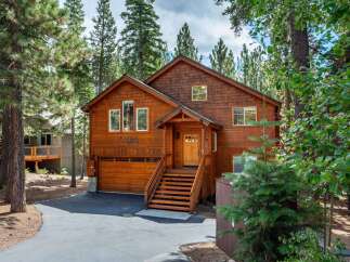 Nestled amidst tall pine trees, this charming wooden home offers a serene mountain retreat.