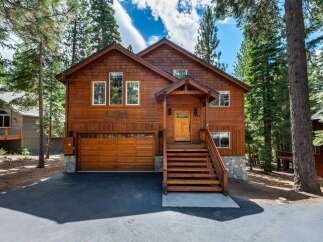 Nestled amongst tall pine trees, this charming wooden cabin offers a serene mountain retreat.