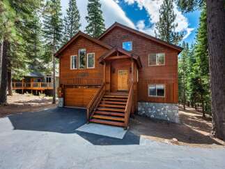 Nestled amidst towering pine trees, this charming wooden home offers a serene mountain retreat.