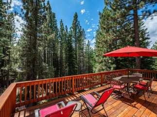 Enjoy the serene mountain lifestyle from this expansive wooden deck, perfect for outdoor dining and relaxation.