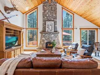 Experience rustic charm in this stunning living room, featuring a grand stone fireplace as the centerpiece.