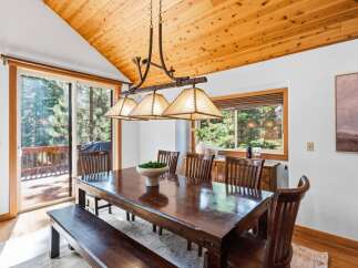 Experience rustic charm in this dining room featuring a large wooden table with a matching bench and chairs, perfect for family gatherings.