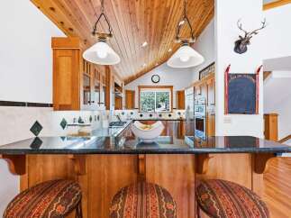 This stunning kitchen boasts rich wood cabinetry and a vaulted wood-paneled ceiling, creating a warm and inviting atmosphere.