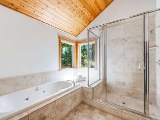 Indulge in relaxation in this luxurious bathroom featuring a spacious jetted tub and a separate glass-enclosed shower.