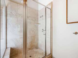 Step into a spa-like experience with this beautifully tiled walk-in shower, featuring a glass enclosure and a built-in bench.