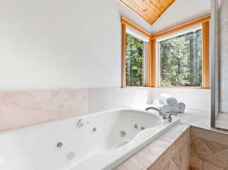 Indulge in relaxation in this luxurious bathroom featuring a spacious jetted tub, perfect for unwinding after a long day.