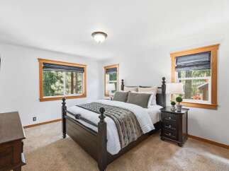 This cozy bedroom features a dark wood four-poster bed adorned with plush bedding and a textured throw.