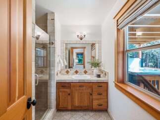 Experience ultimate relaxation in this charming bathroom featuring a spacious walk-in shower and a beautiful wooden vanity.