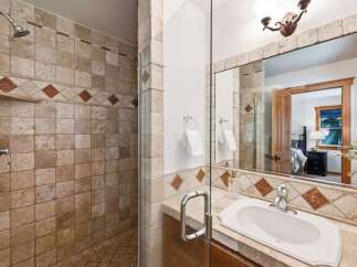 Experience luxury in this beautifully tiled bathroom featuring a spacious walk-in shower with a convenient built-in shelf.