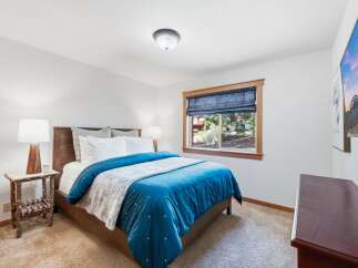 Experience comfort and style in this inviting bedroom, featuring a plush queen-size bed adorned with a vibrant blue comforter and a cozy throw blanket.