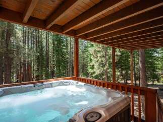 Indulge in ultimate relaxation with this luxurious hot tub, perfectly situated on a covered deck amidst a serene forest setting.