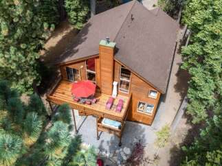 Experience mountain living in this charming wooden cabin, nestled amongst tall pine trees.