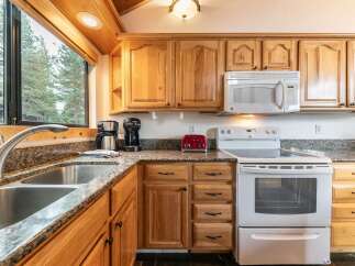 This charming kitchen features beautiful natural wood cabinetry complemented by granite countertops.