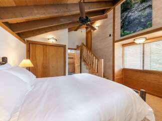 Experience rustic charm in this cozy bedroom featuring a plush white duvet and a natural wood headboard.