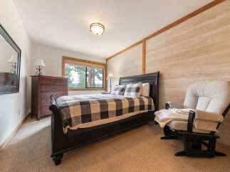 Experience cozy comfort in this charming bedroom, featuring a plush glider chair perfect for relaxation.