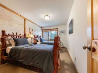 Experience rustic charm in this cozy bedroom featuring two log-frame twin beds, perfect for accommodating guests.