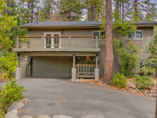 Nestled among tall pine trees, this charming home offers a serene mountain retreat.