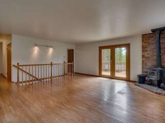 Step into this inviting living space featuring a cozy brick fireplace and a wood-burning stove, perfect for chilly evenings.