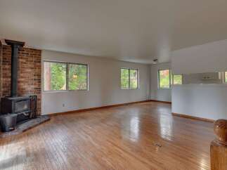 Experience cozy living in this spacious room featuring a charming brick fireplace with a wood-burning stove, perfect for gathering on cooler evenings.