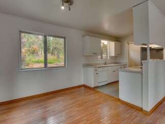 Enjoy the natural beauty surrounding this home with a spacious kitchen featuring ample cabinet space and a large window overlooking the scenic outdoors.