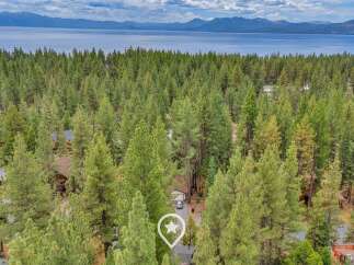 Nestled amidst a lush pine forest, this property offers a serene escape with stunning lake and mountain views in the distance.