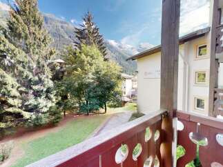 Experience breathtaking mountain views from this charming property, nestled amidst lush greenery and towering pine trees.