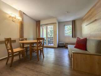 This charming living space features a cozy dining area with a wooden table and chairs, perfect for intimate meals.