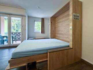 Discover this modern studio apartment featuring a space-saving Murphy bed, perfect for maximizing living area.