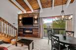 Experience cozy living with this inviting living room featuring a rustic wood-paneled fireplace and a large flat-screen TV.