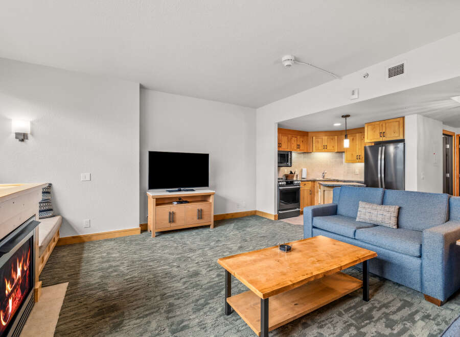 Cozy living room featuring a gas fireplace and a comfortable blue sofa, perfect for relaxing after a day on the slopes.