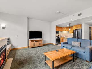 Cozy living room featuring a gas fireplace and a comfortable blue sofa, perfect for relaxing after a day on the slopes.