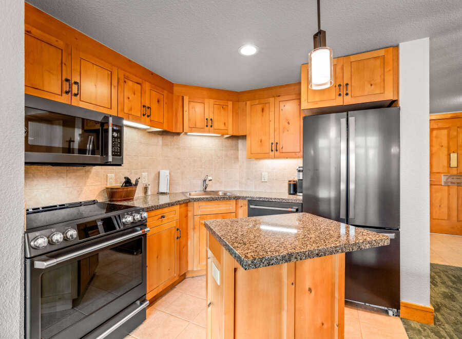 This charming kitchen boasts beautiful light wood cabinetry complemented by granite countertops and a tiled backsplash.