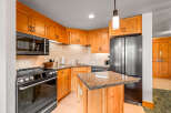 This charming kitchen boasts beautiful light wood cabinetry complemented by granite countertops and a tiled backsplash.
