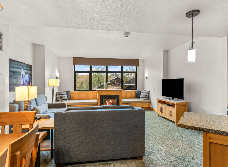 Cozy living room featuring a gas fireplace and large windows with scenic views.