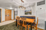 Enjoy meals in this inviting dining area featuring a rustic wooden table with comfortable upholstered chairs and a built-in banquette.