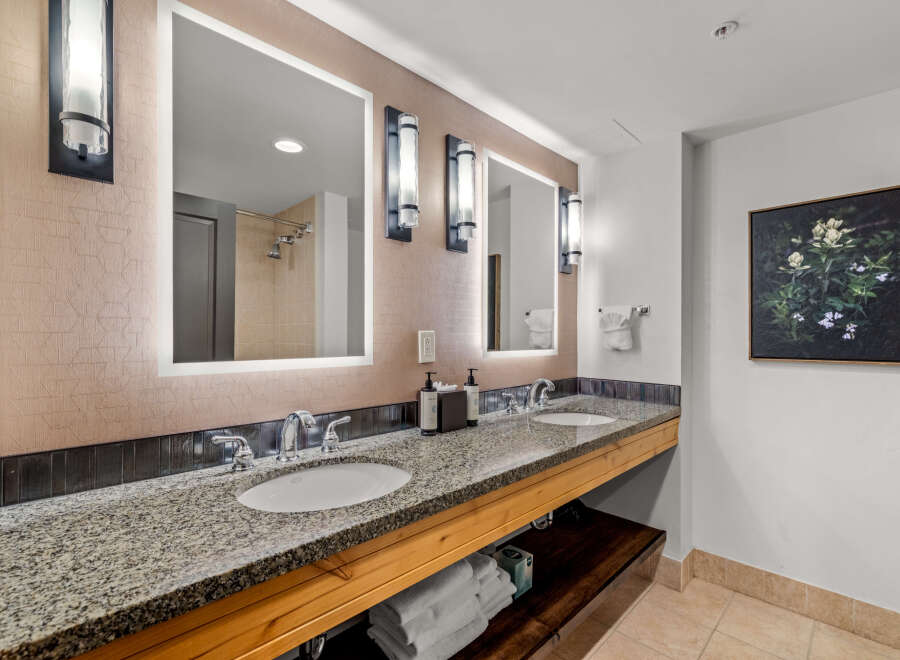 This luxurious bathroom features a spacious double vanity with granite countertops and modern fixtures, perfect for any morning routine.