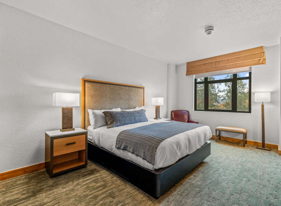 Experience comfort and style in this beautifully appointed hotel room, featuring a plush king-sized bed with elegant bedding and a decorative throw.