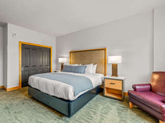 Experience comfort and style in this beautifully appointed bedroom, featuring a plush king-sized bed with a luxurious upholstered headboard.