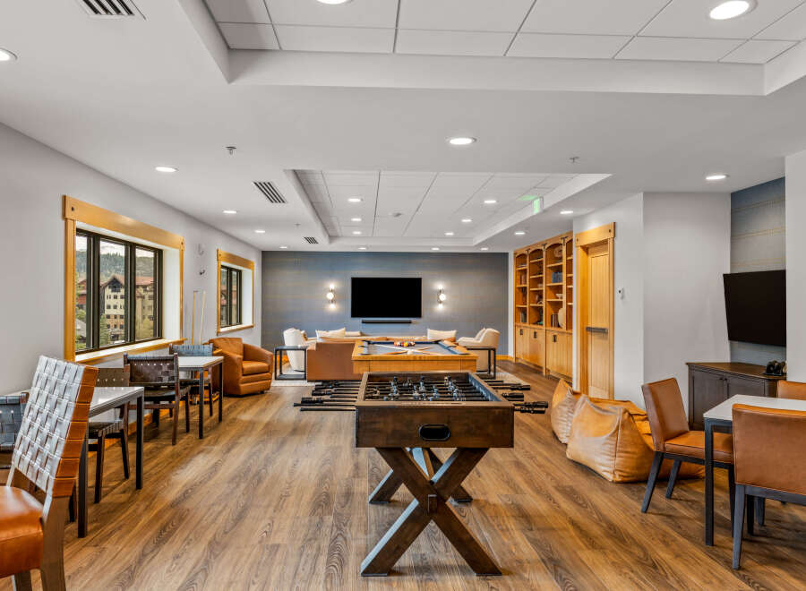 Experience ultimate relaxation and entertainment in this spacious lounge area, featuring a pool table and foosball table for endless fun.