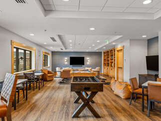 Experience ultimate relaxation and entertainment in this spacious lounge area, featuring a pool table and foosball table for endless fun.