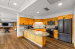 Discover this modern kitchen featuring warm wood cabinetry and a sleek granite countertop island, perfect for casual dining or entertaining.